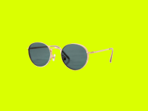 Óculos de Sol com lentes arredondadas e armação dourada, em fundo verde limão.
